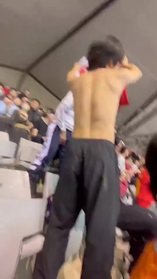 国足球迷高举阿森纳球衣，回击在主场看台穿热刺球衣的球迷