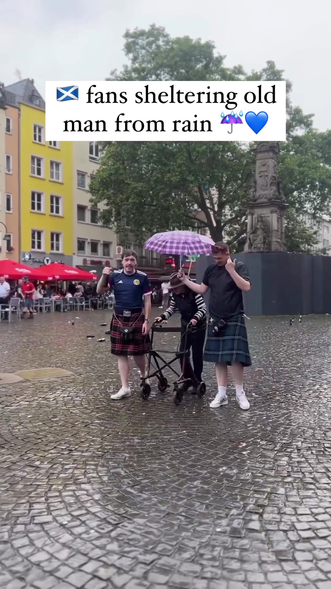 优质球迷苏格兰球迷雨中为老人撑伞前行